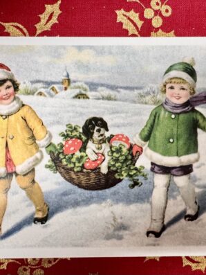 Nostalginen joulukortti, jossa kaksi lasta kantaa lumisessa maisemassa koria, jossa istuu pieni koira neliapiloiden ja kärpässienten keskellä.